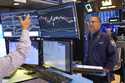 Robert Charmak, right, works on the floor at the New York Stock Exchange in New York, Wednesday, Ju…