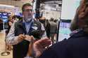 Trader Michael Capolino left, works on the floor of the New York Stock Exchange, Monday, August 18,…