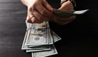 person counting one hundred dollar bills